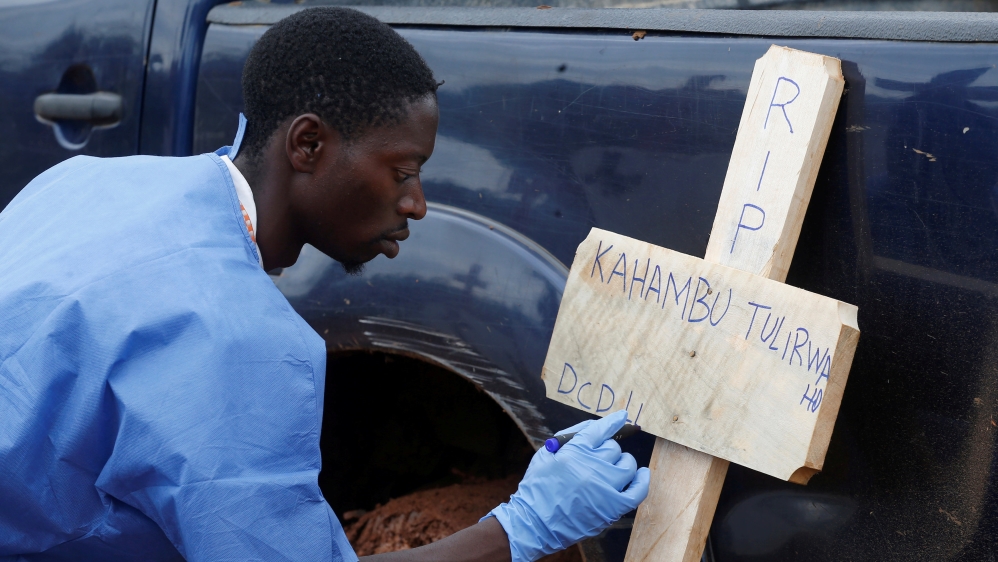 A Congolese red cross worker writes on a cross the name of Congolese woman Kahambu Tulirwaho who died of Ebola, before a burial service at a cemetery in Butembo in the Democratic Republic of Congo
