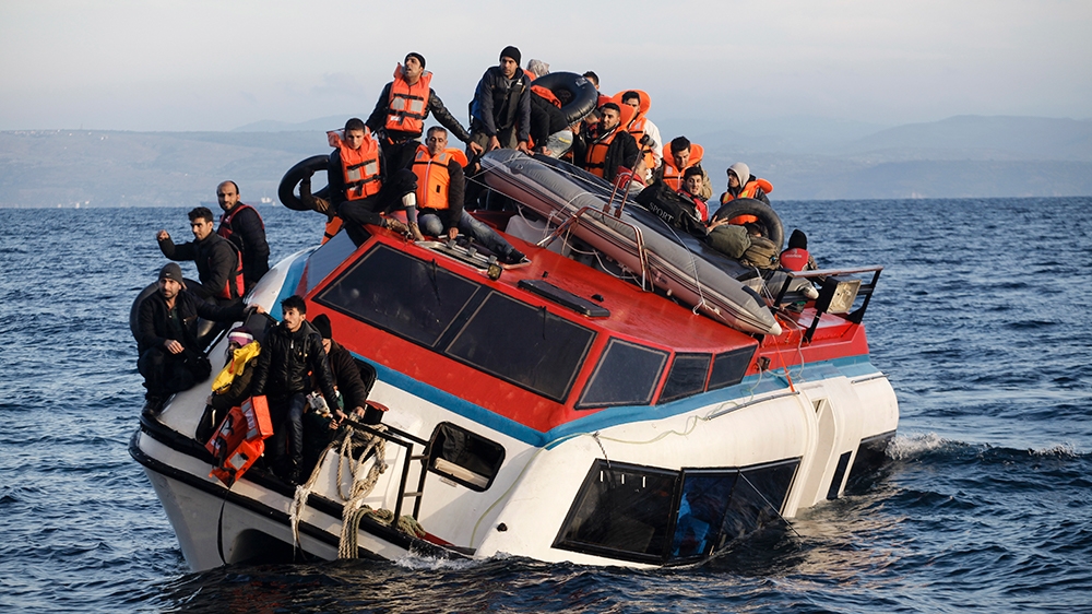 Refugees and migrants sit atop a heavily-listing small vessel as they try to travel from the Turkish coast to Skala Sykaminias on the northeastern Greek island of Lesbos on Friday, Oct. 30, 2015. Auth