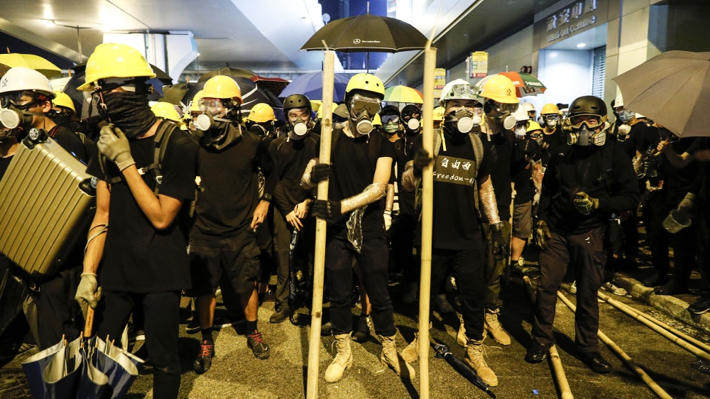 Protesters prepare to confront riot police in Hong Kong on Sunday, July 21, 2019. Protesters in Hong Kong pressed on Sunday past the designated end point for a march in which tens of thousands repeate