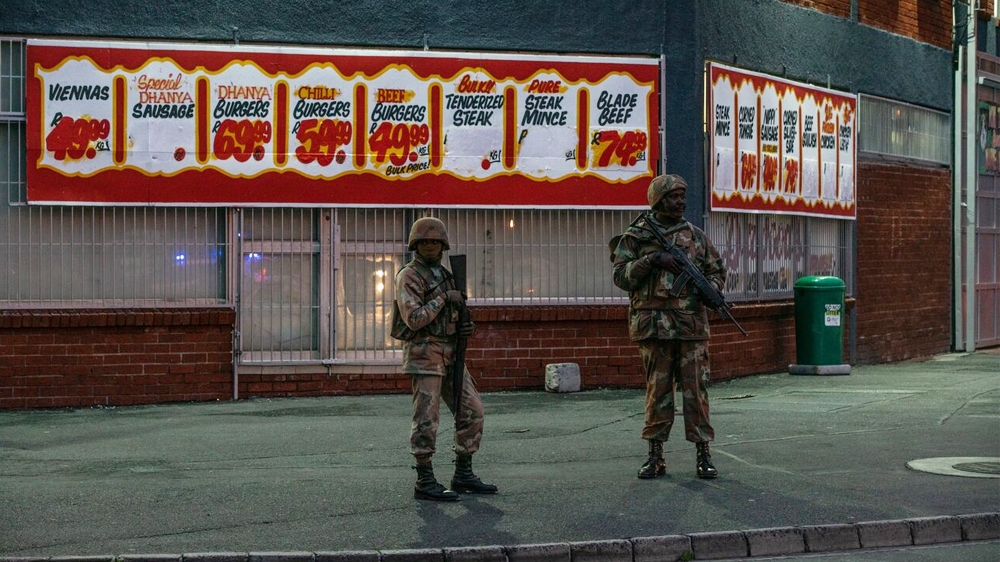 Soldiers stand in front of a shop in Hanover Park, in a heavily gang-afflicted area on the Cape Flats [Shaun Swingler/Al Jazeera]