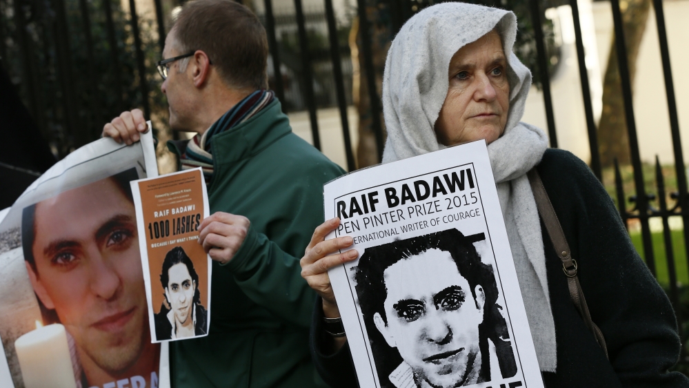 Demonstrators hold placards during a protest for Saudi blogger Raif Badawi, outside the Saudi embassy in London