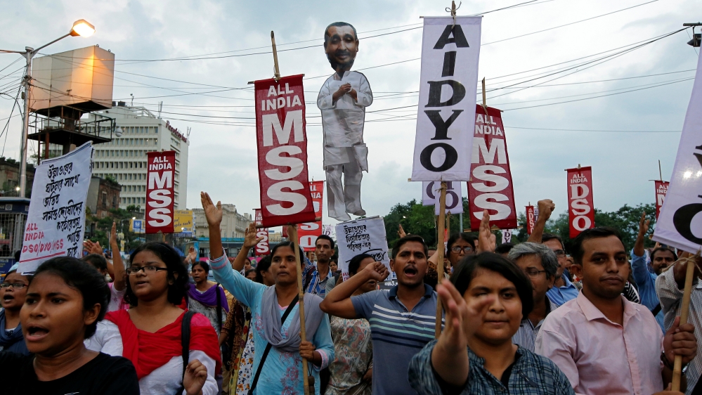 People shout slogans as they carry an effigy depicting Kuldeep Singh Sengar, a legislator of the ruling BJP, during a protest demanding jus