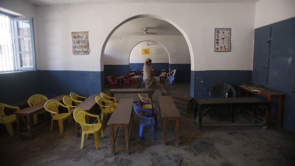A Kashmiri school staff member cleans a deserted classroom in Srinagar, Indian controlled Kashmir, Monday, Aug. 19, 2019.