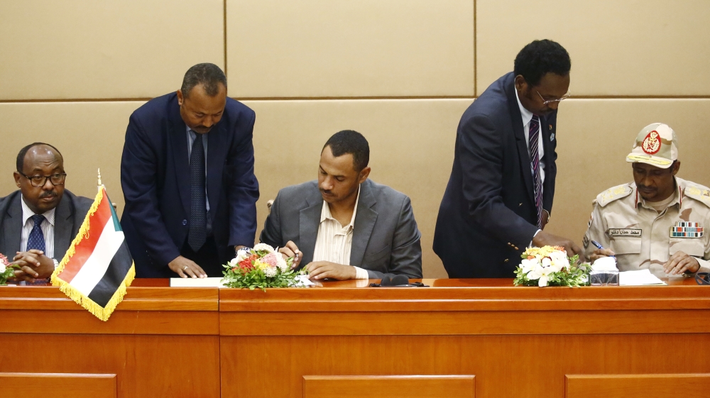L to R) Ethiopian mediator Mahmoud Drir attends the signing of the constitutional declaration between protest leader Ahmad Rabie and General Mohamed Hamdan Daglo, Sudan''s deputy head of the Transition