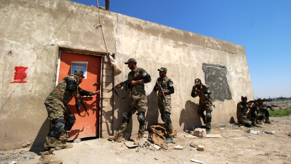 Members of the paramilitary Popular Mobilisation Forces storm as part of a training at their camp in Basra