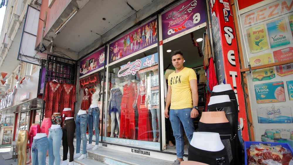 Syrian shopkeeper Mustafa poses in front of his clothes shop in Istanbul''s Kucukcekmece district