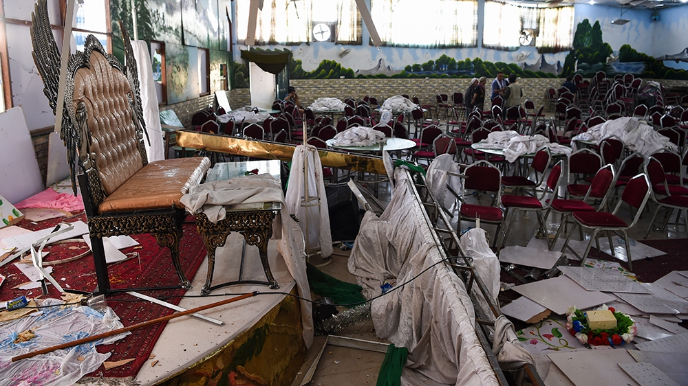 Afghan men investigate in a wedding hall after a deadly bomb blast in Kabul on August 18, 2019. - More than 60 people were killed and scores wounded in an explosion targeting a wedding in the Afghan c