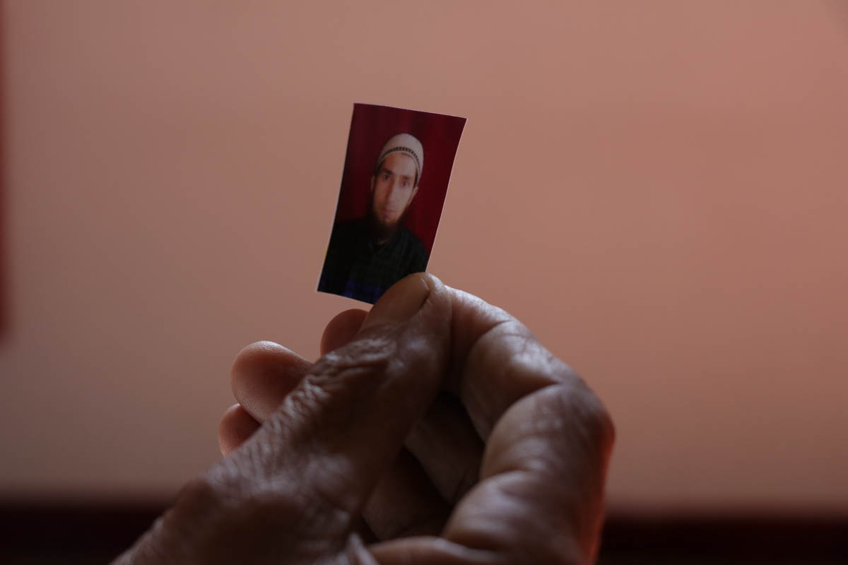 Rehmandar holds portrait of his son bilalahmaddar who was picked up by government forces from his house  during midnight in kareemabad  village of south Kashmir , Bilal was  charged with Public safety