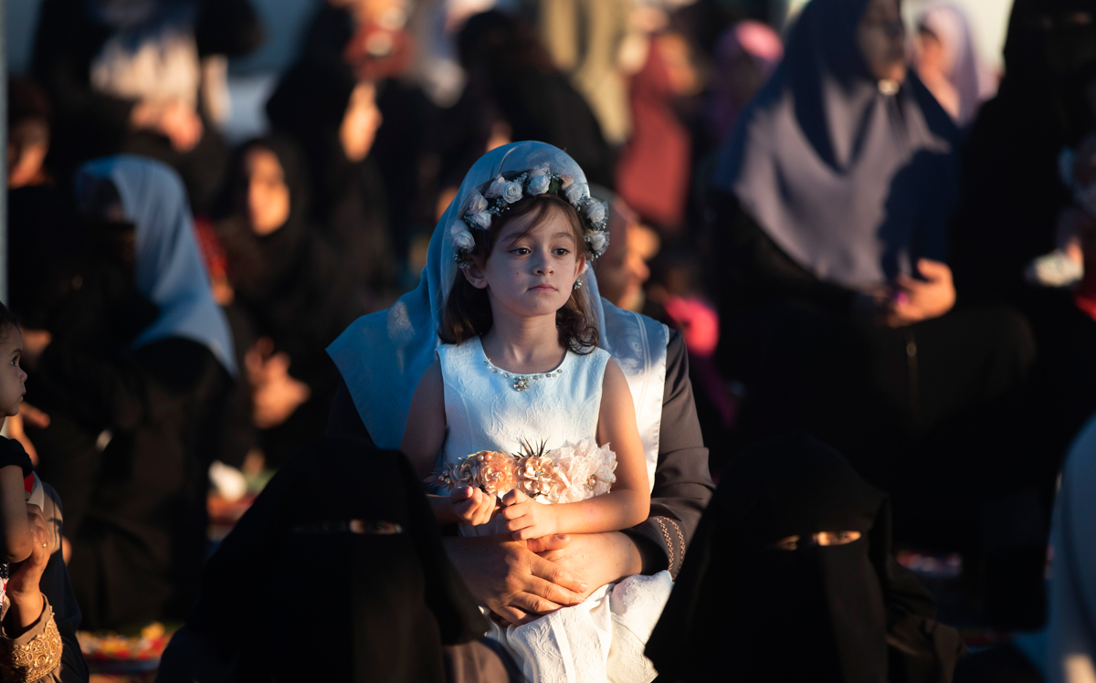 A Palestinian girl dressed up as she attends prayers to mark the first day of Eid al-Adha, in Gaza City, Sunday, Aug. 11, 2019. During the Eid al-Adha, or Feast of Sacrifice, Muslims slaughter sheep o