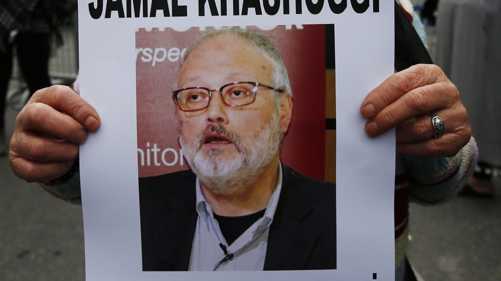 An activist, member of the Human Rights Association Istanbul branch, holds a poster with a photo of missing Saudi journalist Jamal Khashoggi, during a protest in his support near the Saudi Arabia cons