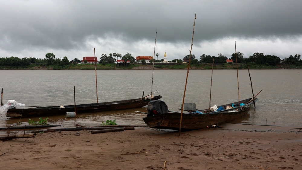 Pagoda from Laos is seen under a rain cloud from across the Mekong River in Nakhon Phanom