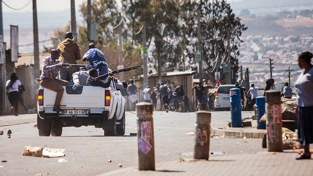 Plainclothes members of the South African Police Service fire rubber bullets toward residents of the Johannesburg township of Alexandra on September 3, 2019 after South Africa''s financial capital was