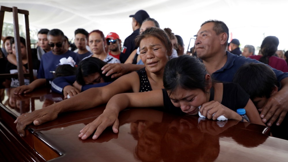Relatives of a police officer, who was killed along other fellow police officers during an ambush by suspected cartel hitmen, react during an homage organised by the state government, in Morelia