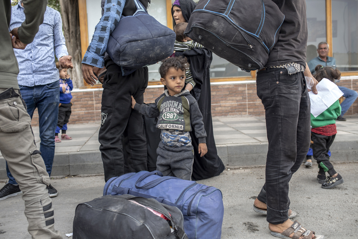 A boy stand by his father as they wait to board buses driving them back to various areas of Turkey’s Gaziantep