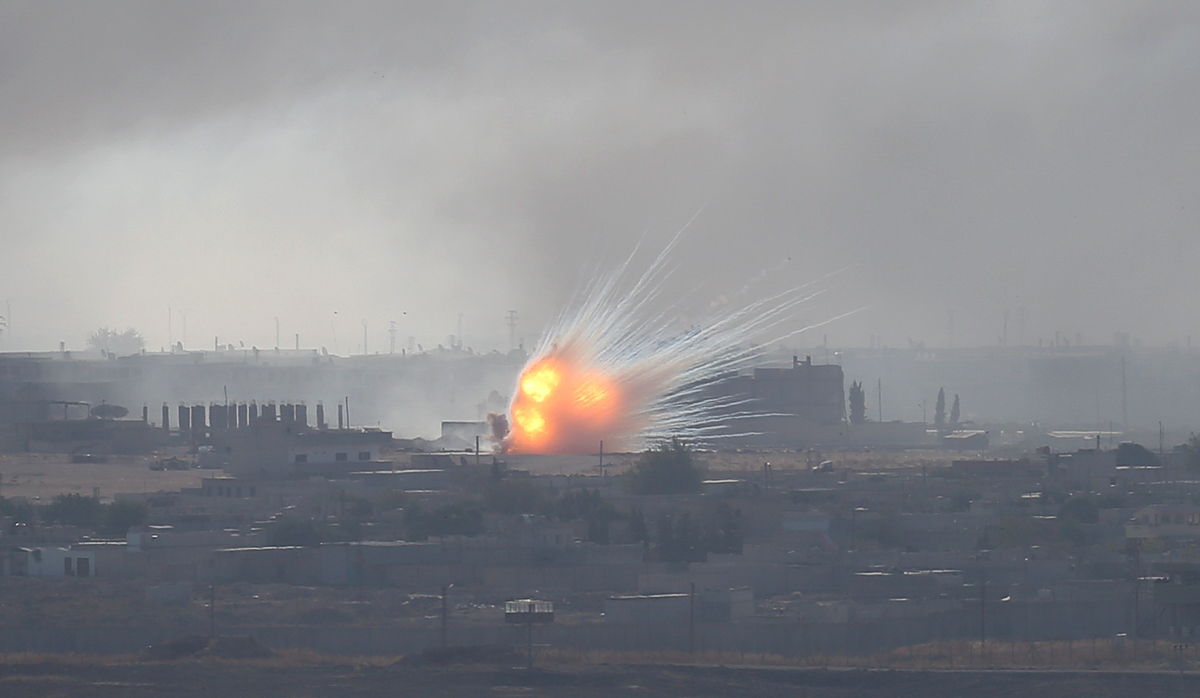 An explosion is seen over the Syrian town of Ras al-Ain as seen from the Turkish border town of Ceylanpinar, Sanliurfa province, Turkey, October 12, 2019. REUTERS/Stoyan Nenov