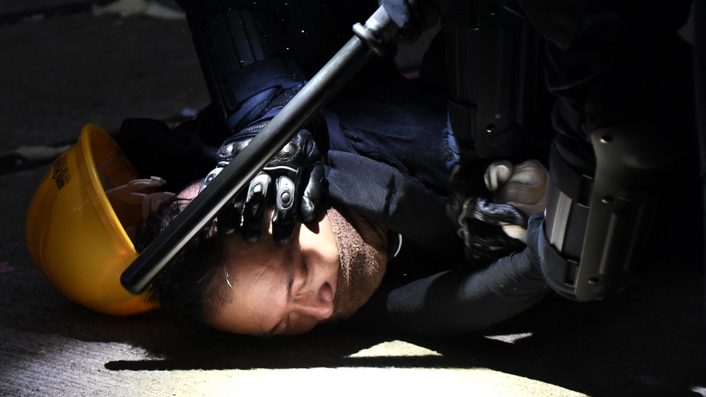 A man is detained by police during clashes in the Wanchai district in Hong Kong on October 1, 2019, as the city observes the National Day holiday to mark the 70th anniversary of communist China''s fou