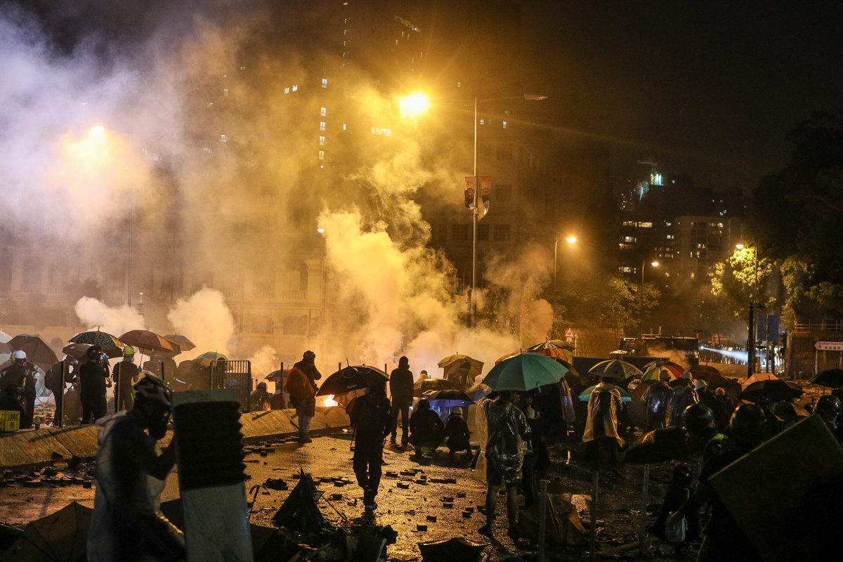 Pro-democracy protesters react after the police fired tear gas outside the Polytechnic University of Hong Kong in Hong Kong, China, 17 November 2019. Hong Kong is in its sixth month of mass protests,