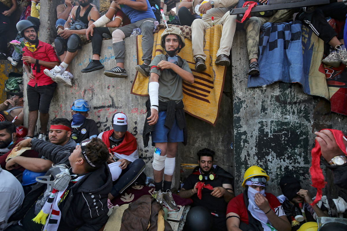 Iraqi demonstrators take part in ongoing anti-government protests, near al-Jumhuriya bridge which leads to the high-security Green Zone, in the capital Baghdad on November 4, 2019. - Iraqi security fo