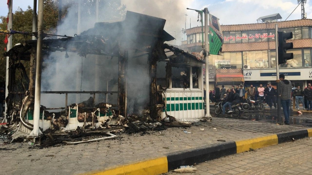 Iranians gather around a charred police station that was set ablaze by protesters during a demonstration against a rise in gasoline prices in the central city of Isfahan on November 17