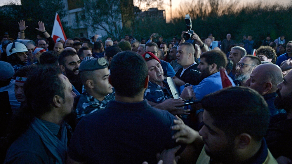 Lebanese Internal Security Forces separate between supporters of the Lebanese President (R) and anti-government protesters (L) at the highway leading to the Presidential palace during a protest to de