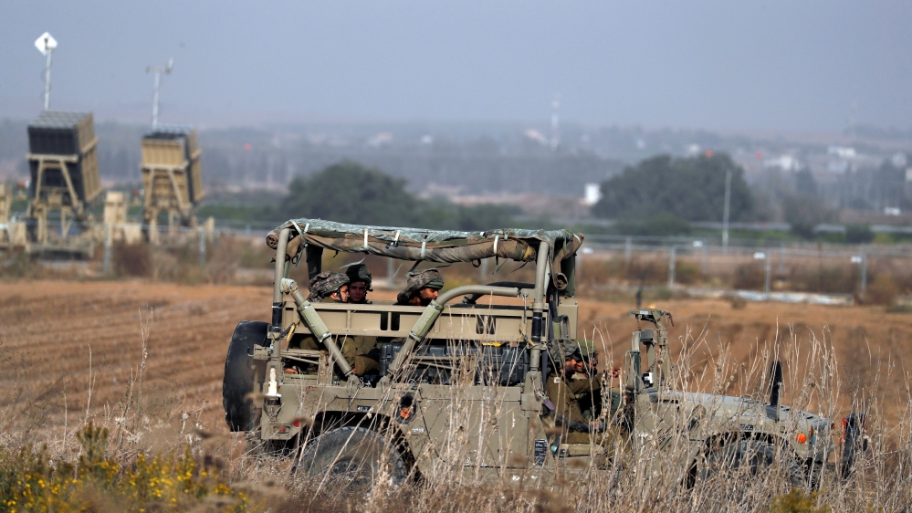 Israeli soldiers ride a military jeep in an area near the Gaza border, in southern Israel