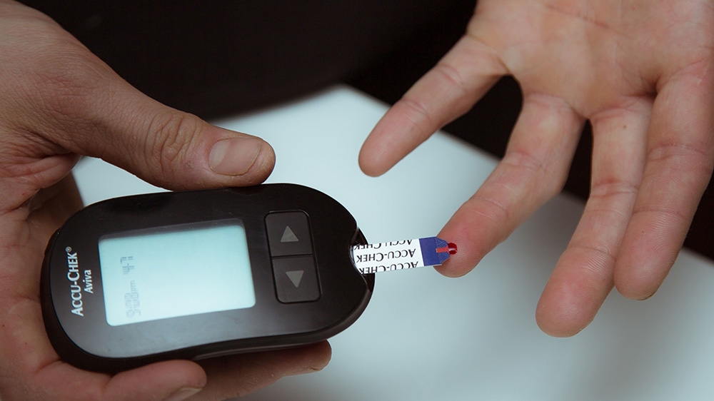 A diabetic person tests blood sugar levels using a Roche Diabetes Care Inc. Accu-Chek brand glucose meter in an arranged photograph taken in the Brooklyn borough of New York, US, April