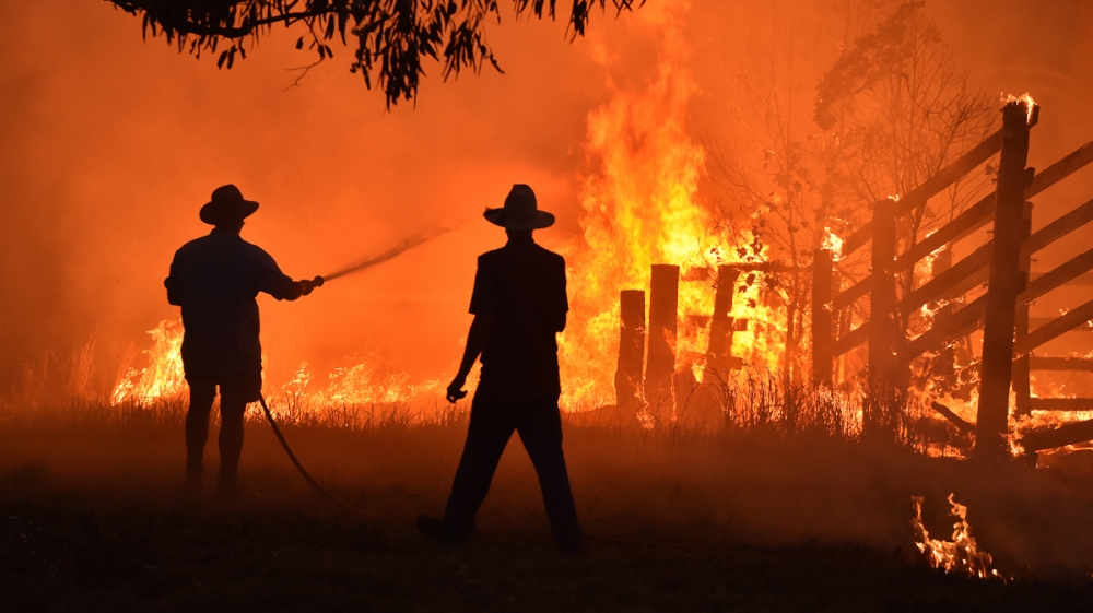 Residents defend a property from a bushfire at Hillsville near Taree, 350km north of Sydney on November 12, 2019. - A state of emergency was declared on November 11 and residents in the Sydney area we