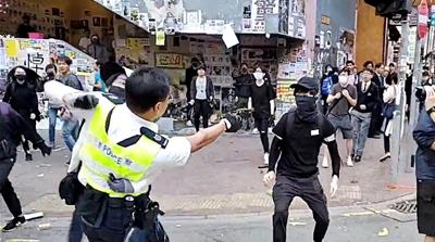 A still image from a social media video shows a police officer aiming his gun at a protester in Sai Wan Ho, Hong Kong, China November 11, 2019. CUPID PRODUCER via REUTERS