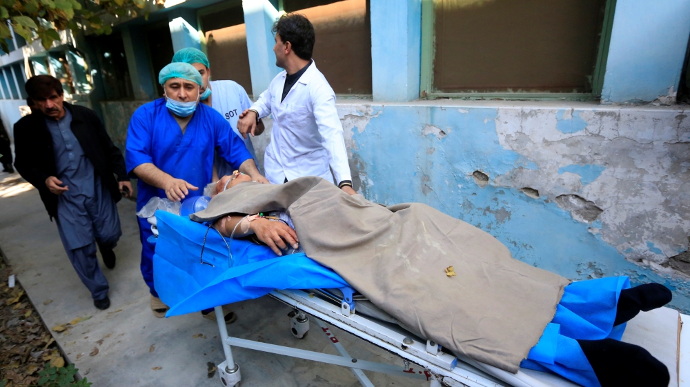 Hospital workers carry Japanese doctor Tetsu Nakamura to a hospital after an attack in Jalalabad