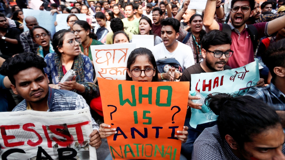 Students hold placards and shout slogans in solidarity with Jamia Millia Islamia university students after police entered the campus on the previous day in New Delhi, following a protest against a new