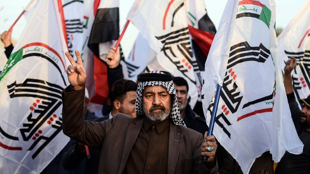Iraqis wave Hashed Al-shaabi armed network flags on December 30, 2019, during a demonstration in holy shrine city of Najaf to denounce the previous night''s attacks by US planes on several bases belong