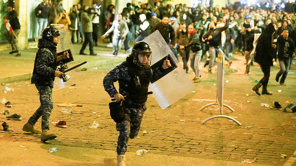 A riot police runs for cover during anti government protests in Beirut, Lebanon December 15, 2019. REUTERS/Mohamed Azakir