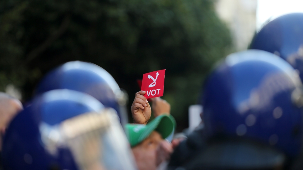 A demonstrator holds a sign reading "No vote", during a protest rejecting the presidential election in Algiers