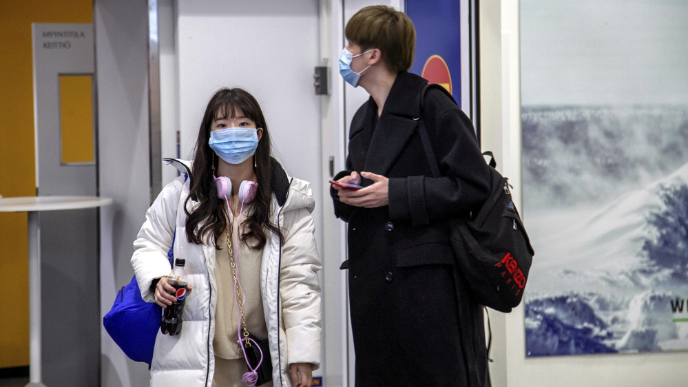 Air travellers wear masks as they arrive at Ivalo Airport, Finland January 24, 2020. On Thursday, two tourists visiting Finland from Wuhan, China went to a health centre in Ivalo, seeking treatment fo