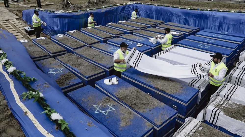 Volunteers perform the final rites before burying the remains of Holocaust victims at a cemetery just outside Brest, Belarus, Wednesday, May 22, 2019. Remains of more than 1,000 Holocaust victims were