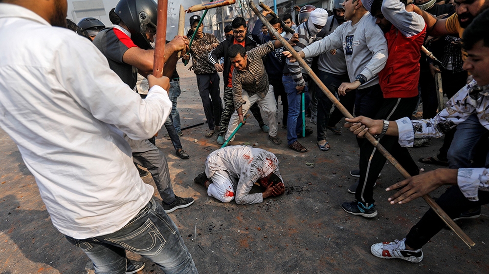 SENSITIVE MATERIAL. THIS IMAGE MAY OFFEND OR DISTURB People supporting the new citizenship law beat a Muslim man during a clash with those opposing the law in New Delhi, India, February 24, 2020. R
