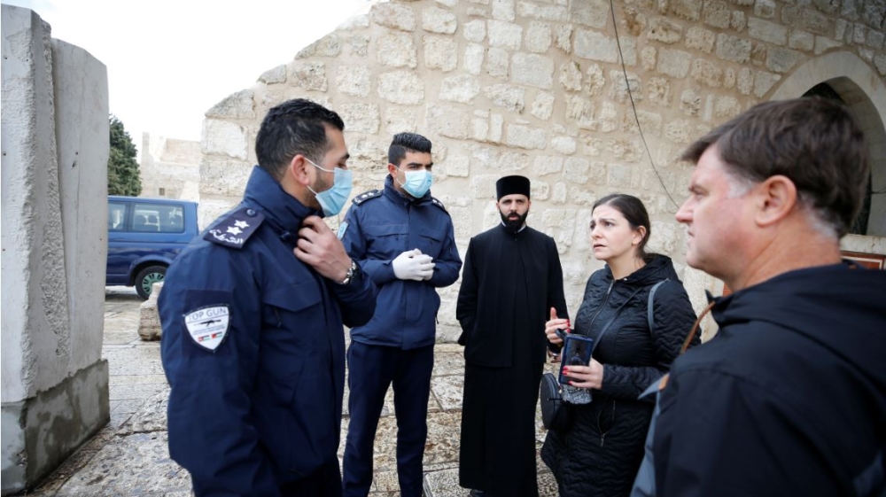 Palestinian police officers stand guard outside the Church of the Nativity that was closed as a preventive measure against the coronavirus in Bethlehem in the Israeli-occupied West Bank