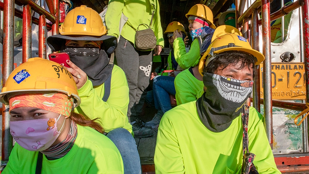 Migrant construction workers exit a truck after concluding day's work in Bangkok, Thailand, Thursday, March 26, 2020. A month-long state of emergency has been enforced in Thailand to allow its governm