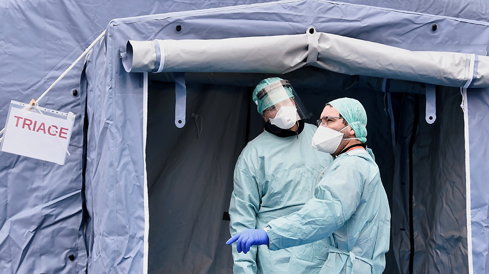 Medical workers wearing protective masks wait by a medical checkpoint at the entrance of the Spedali Civili hospital in Brescia, Italy March 3, 2020. REUTERS/Flavio Lo Scalzo