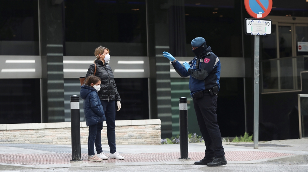 A police officer talks to a woman outside a hotel that has been set up to treat non-critical coronavirus patients during the coronavirus disease (COVID-19) health emergency in Madrid, Spain, March 19,