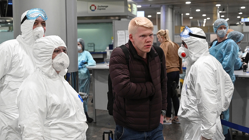 Russian officials and medical staff wearing protective gear check passengers as a preventive measure against the coronavirus (COVID-19) at Sheremetyevo International Airport outside Moscow, Russia Mar