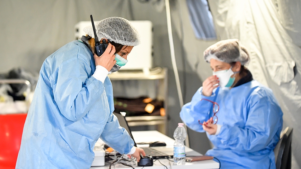 Paramedics work in a tent that was set up outside the hospital of Cremona, northern Italy, Saturday, Feb. 29, 2020. A U.S. government advisory urging Americans to reconsider travel to Italy due to the