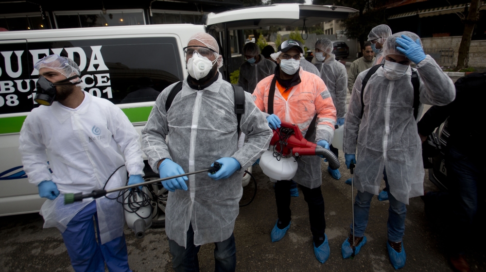 Palestinians workers in a protective suits get ready to disinfect mosques and churches as a preventive measure against the coronavirus in the West Bank city of Ramallah, Saturday, March 7, 2020.(AP Ph