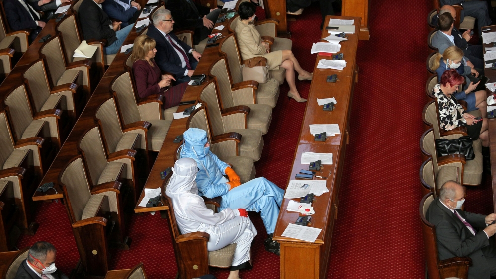 Leader of Bulgarian party Volya, Mareshki, and a deputy from his party wear protective suits during debates in the parliament in Sofia