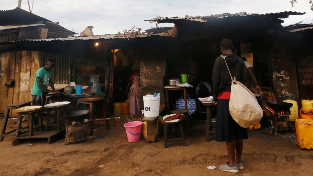 A woman stands outside a shop at the end of a night-long curfew ordered by Kenya''s President Uhuru Kenyatta to slow the spread of the coronavirus disease (COVID-19), in Nairobi