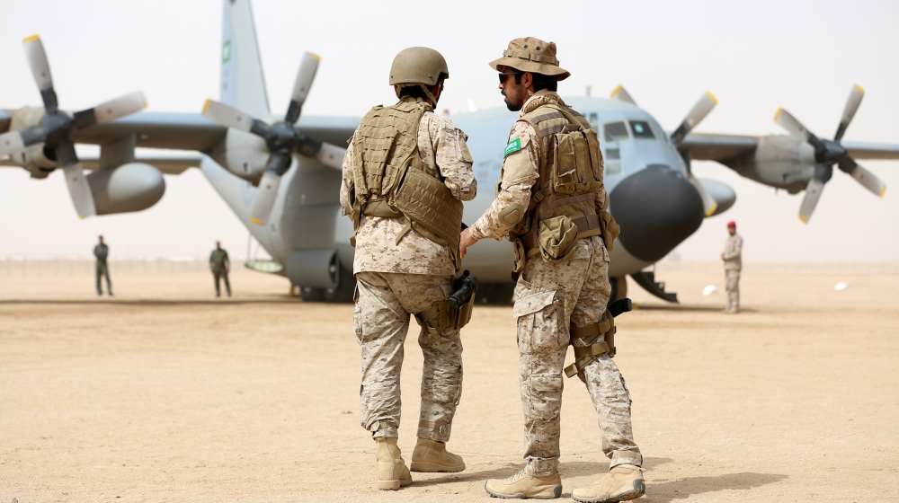 Saudi soldiers walk past a Saudi air force cargo plane delivering aid at an airfield in the northern province of Marib, Yemen January 22, 2018. REUTERS/Ali Owidha - RC1BB0D15910