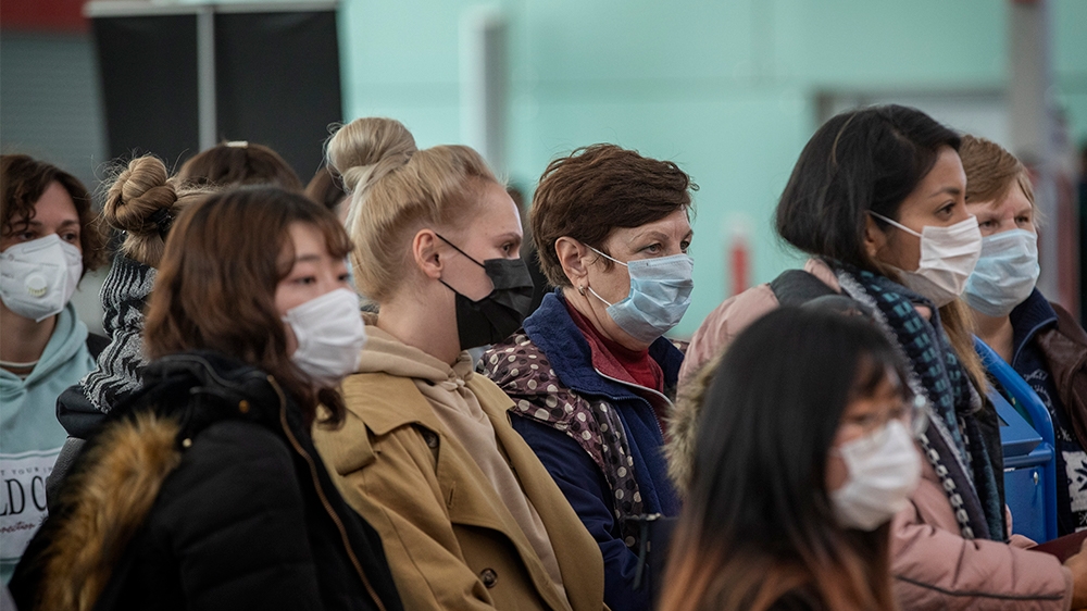 Passengers wearing masks line up as they wait to check in at the Barcelona airport, Spain, Saturday, March 14, 2020. Spain''s prime minister has announced a two-week state of emergency from Saturday in