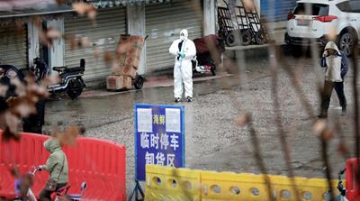 A worker in a protective suit is seen at the closed seafood market in Wuhan