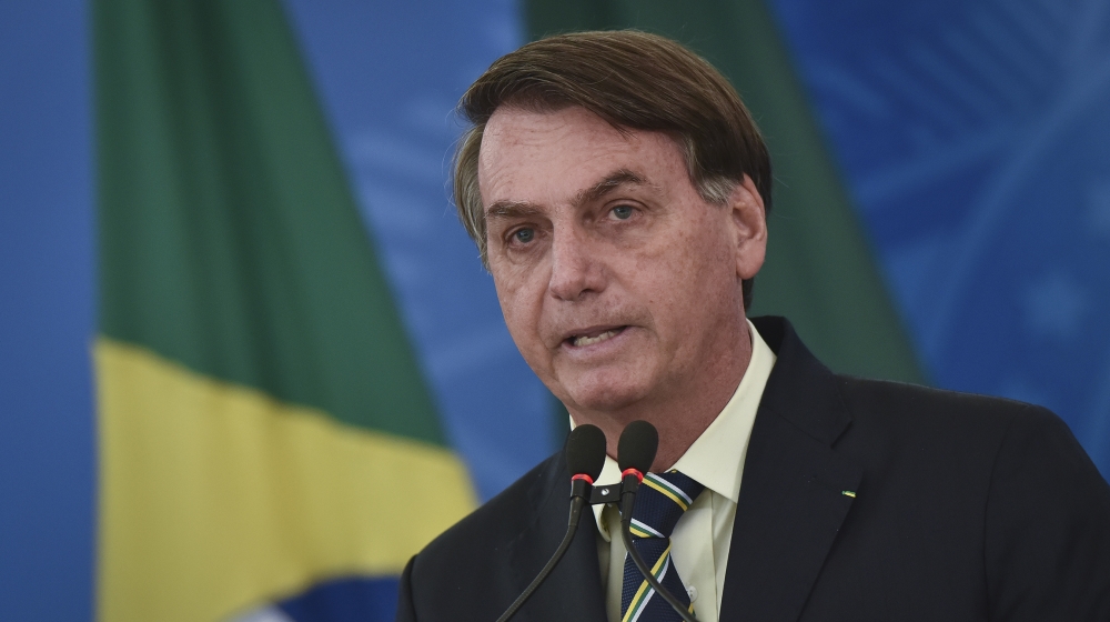 Brazil's President Jair Bolsonaro speaks to journalists about the new coronavirus at Planalto presidential palace in Brasilia, Brazil, Friday, March 27, 2020. Even as the new coronavirus cases mount i