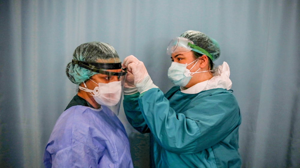 Nurse Dilara Fahrioglu adjusts Kamer Demir''s protective face mask before they start to take care patients suffering from the coronavirus disease (COVID-19) at the intensive care unit of the Medicana I